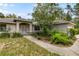 Charming single-story home featuring a well-manicured lawn and inviting front entrance with decorative glass door at 9879 Sw 38Th Ave, Ocala, FL 34476