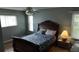 Cozy bedroom with neutral walls, hardwood floors, large windows and a lamp at 32932 Crooked Oaks Ln, Leesburg, FL 34748