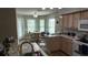 Eat-in kitchen with wood cabinets, stainless steel appliances, and a cozy breakfast nook by the windows at 32932 Crooked Oaks Ln, Leesburg, FL 34748