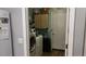 Functional laundry room with side-by-side washer and dryer and overhead storage cabinets at 32932 Crooked Oaks Ln, Leesburg, FL 34748
