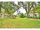 Large backyard features mature trees, green grass, and a view of the home's exterior at 103 13Th Se St, Winter Haven, FL 33880