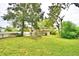 A spacious backyard includes a lush lawn, mature trees, a back porch, and a chain-link fence at 103 13Th Se St, Winter Haven, FL 33880