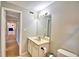 Bathroom featuring a single sink vanity, framed mirror, toilet, and a glimpse into the hallway at 103 13Th Se St, Winter Haven, FL 33880