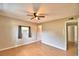 A bedroom featuring wood-look flooring, a ceiling fan, a window with gray curtains, and neutral-colored walls at 103 13Th Se St, Winter Haven, FL 33880