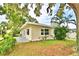 Exterior side view of home shows a well-maintained lawn, mature trees, and a small back patio at 103 13Th Se St, Winter Haven, FL 33880