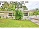 Charming single-story home features a well-manicured front yard, tropical plants, and a brick chimney at 103 13Th Se St, Winter Haven, FL 33880