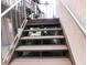 Exterior staircase with wooden steps and metal handrail to an upper level, with plants and trees below at 218 La Casa, Lake Wales, FL 33898