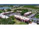 Aerial view showcasing a serene community setting with lush landscaping, parking, and nearby lake at 220 La Casa # 220, Lake Wales, FL 33898