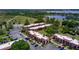 Scenic aerial view of condos, parking, tennis court, and lake, creating a park-like setting at 220 La Casa # 220, Lake Wales, FL 33898