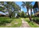 Beautifully landscaped grounds with lush green lawn and mature trees leading to a charming gazebo at 220 La Casa # 220, Lake Wales, FL 33898
