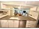 Well-lit kitchen showcasing stylish cabinets, stainless steel dishwasher, and sink with view to the living room at 220 La Casa # 220, Lake Wales, FL 33898