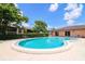 Community swimming pool surrounded by lush landscaping and comfortable lounge seating at 220 La Casa # 220, Lake Wales, FL 33898