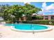 Community swimming pool surrounded by lush landscaping, and clear blue skies at 220 La Casa # 220, Lake Wales, FL 33898