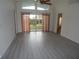 Bright living room with wood-look floors, sliding glass doors, and high ceilings at 231 Lake Suzanne Dr, Lake Wales, FL 33859