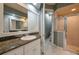 Well-lit bathroom features a granite vanity, large mirror, and a glass shower, providing modern comfort and style at 3017 Mission Lakes Dr, Lakeland, FL 33803