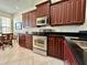 Well-lit kitchen features stainless steel appliances, dark wood cabinets, and granite countertops at 3017 Mission Lakes Dr, Lakeland, FL 33803