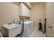 Well-lit laundry room features a washer, dryer, utility sink, white cabinets, and tile flooring at 3017 Mission Lakes Dr, Lakeland, FL 33803