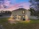 Backyard view of a two-story home, fenced yard, and a patio area at 1029 Evans Loop, Lake Wales, FL 33853