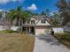 Charming two-story home with tan siding, brick accents, a two-car garage, and a well-manicured lawn at 1029 Evans Loop, Lake Wales, FL 33853