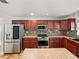 Spacious kitchen featuring stainless steel appliances, rich wood cabinetry, and a decorative tile backsplash at 1029 Evans Loop, Lake Wales, FL 33853