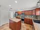 Kitchen featuring stainless steel appliances, wood cabinets, tiled floors, and an island at 1029 Evans Loop, Lake Wales, FL 33853