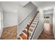 Staircase featuring wood treads and a white handrail leading to an open living space at 1029 Evans Loop, Lake Wales, FL 33853