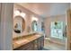 Well-lit bathroom with double vanity, stylish mirrors, granite countertops, and modern fixtures at 112 Reedy Creek Dr, Frostproof, FL 33843