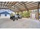 Covered carport with concrete parking area, shed and ATV at 112 Reedy Creek Dr, Frostproof, FL 33843