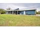 Exterior view of a blue home featuring a well-maintained lawn and screened porch at 112 Reedy Creek Dr, Frostproof, FL 33843