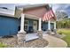 Front porch with stone columns, American flag and rocking chairs at 112 Reedy Creek Dr, Frostproof, FL 33843