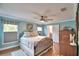 Cozy main bedroom featuring a ceiling fan, windows, and an en-suite bathroom for added comfort and convenience at 112 Reedy Creek Dr, Frostproof, FL 33843