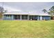 View of the home's blue rear exterior with screened-in porch and green lawn at 112 Reedy Creek Dr, Frostproof, FL 33843