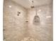 Luxurious tiled shower with rainfall shower head, handheld wand, and built-in niche for storage at 112 Reedy Creek Dr, Frostproof, FL 33843