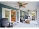 Relaxing screened porch with multiple seating areas and ceiling fans at 112 Reedy Creek Dr, Frostproof, FL 33843