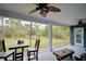 Inviting screened porch featuring a table, chairs, and peaceful backyard views at 112 Reedy Creek Dr, Frostproof, FL 33843