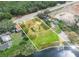 Aerial view of property with lush green lawn, lake access, and mature trees at 1120 S Scenic Hwy, Lake Wales, FL 33853