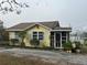 Yellow house with a screened porch and landscaped yard at 1120 S Scenic Hwy, Lake Wales, FL 33853