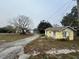 Exterior view of a quaint yellow home with mature trees and a long driveway at 1120 S Scenic Hwy, Lake Wales, FL 33853