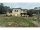 Two story exterior of a yellow home with a fenced front yard, green grass, and mature trees at 1120 S Scenic Hwy, Lake Wales, FL 33853