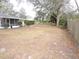 Large backyard with mature trees and wooden fence at 1163 Cephia St, Lake Wales, FL 33853