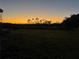 Sunset view over the grassy backyard at 2000 Mcclellan Rd, Frostproof, FL 33843