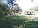 Large backyard with grassy area, detached shed, and mature trees at 2153 Capps Rd, Lake Wales, FL 33898