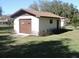 Single car detached garage with brown door and window at 2153 Capps Rd, Lake Wales, FL 33898