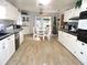 Kitchen features white cabinets and wood-look flooring at 2153 Capps Rd, Lake Wales, FL 33898