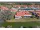 Overhead view of a tile-roofed home overlooking a serene pond with lush landscaping in a tranquil neighborhood at 2680 Clubhouse Dr, Lake Wales, FL 33898