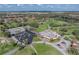 Aerial view highlighting the golf course, restaurant, and parking area with verdant trees in a vibrant community at 2680 Clubhouse Dr, Lake Wales, FL 33898