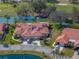 Scenic aerial view of a home with a tile roof with mature trees and tropical landscaping near a lake and golf course at 2680 Clubhouse Dr, Lake Wales, FL 33898