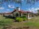 Beautiful exterior view of a home with a red tile roof, a chimney, lush landscaping, and an outdoor patio area at 2680 Clubhouse Dr, Lake Wales, FL 33898