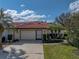 Charming home with a tile roof, well-maintained landscaping, and a two-car garage on a sunny day at 2680 Clubhouse Dr, Lake Wales, FL 33898