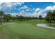 Golf course green with sand trap and flag surrounded by lush green fairway at 2680 Clubhouse Dr, Lake Wales, FL 33898